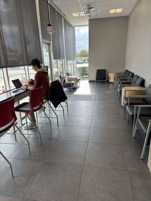 Waiting area has plenty of chairs and also tables with usb and outlets