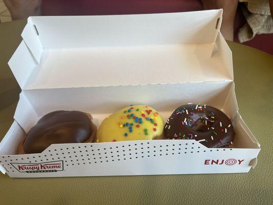 This is a picture of three doughnuts. One being a chocolate iced cream filling, cake batter, chocolate glazed with sprinkles.