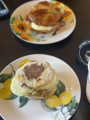 English muffin egg and cheese and croissant sausage egg and cheese in the background