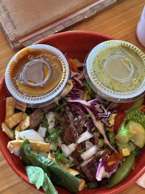 Steak bowl with red dragon and green dragon sauces on the side for an extra kick of heat in your mouth.