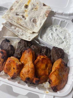 Spicy chicken and beef kabob plate. With rice and cucumber yogurt side.