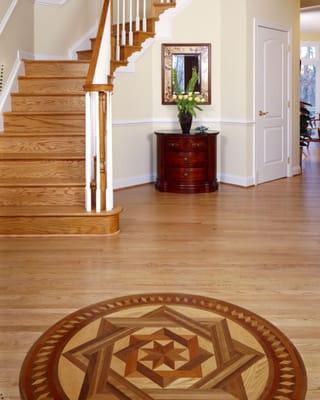 Gorgeous pattern is the centerpiece of  this Herndon grand foyer.  Features a  grand open stairway and custom wood inlay.