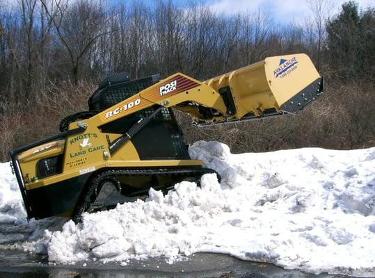 ASV pushing back piles of snow to make more room.