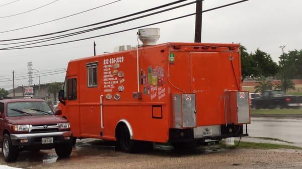 Taco truck in the parking lot with 1.50 papusas y tacos