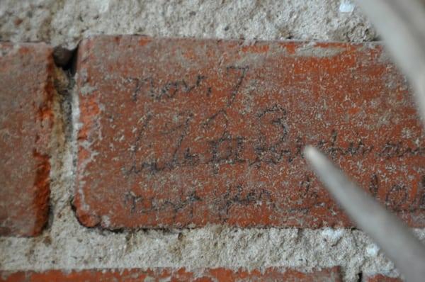 An old brick uncovered on one of the walls inside the store has a date of 11/7/1923