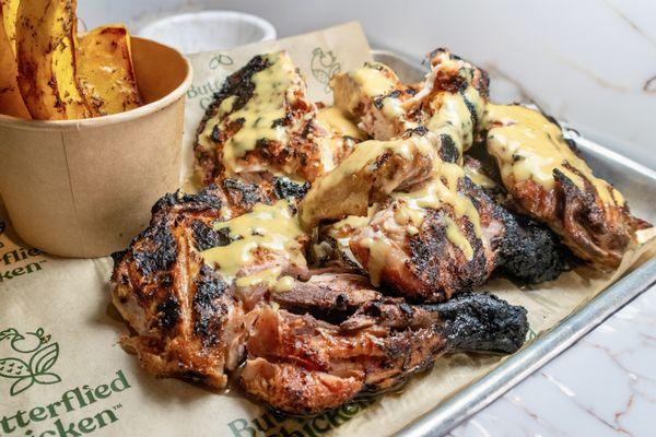 Juicy grilled chicken with chunky fries on the side.