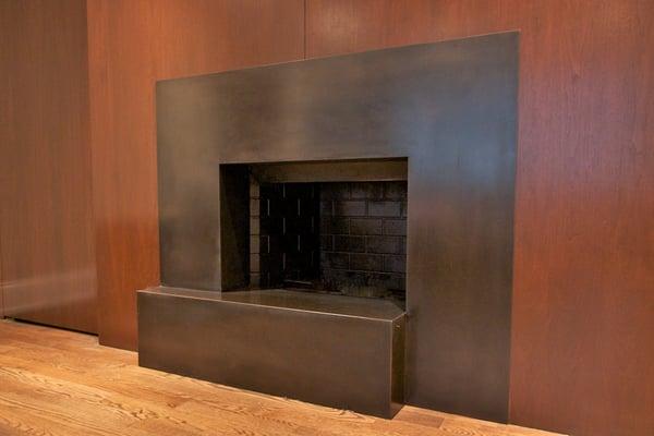 Blackened steel fireplace surround with custom bronze patina. Fabricated by Iron & Wire.