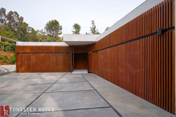 2 seamless modern slab garage doors concealed with wooden trim.