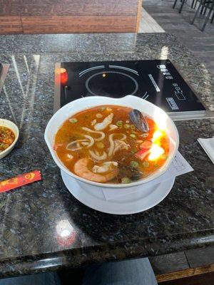 Seafood udon bowl with spicy soup base.