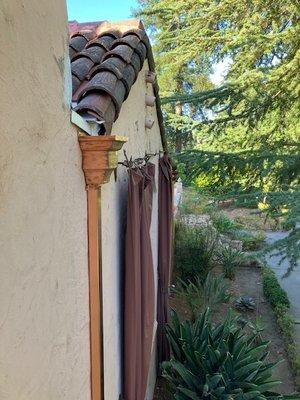 Tile roof with existing tiles and spectacular copper downspouts.