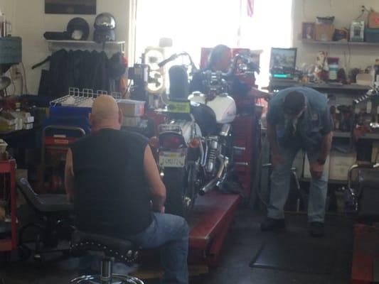 Here's Joe at the front of my bike between the handlebars working on my Shovelhead.