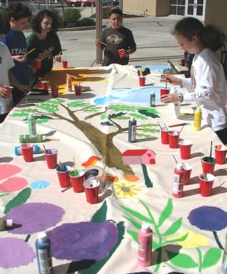 Students reach out to those in need, locally and globally. Here students are painting a tent for a family in Darfur