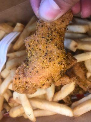 Lemon Pepper Wing in a sea of fries.