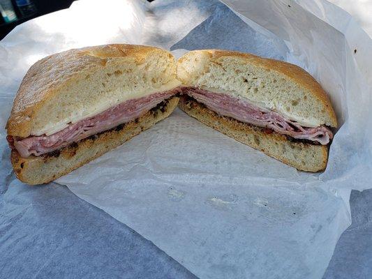 Muffaletta sandwich salami Capicola black forest ham provolone black olive tapenade garlic aoli