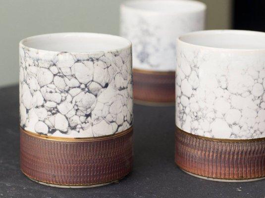 Spectacular pottery by Hedy Yang features rings of 22K gold.