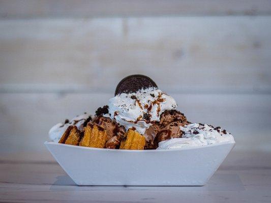 Oreo Churro Delight: Warm Churro Bites topped with Ice Cream, Sprinkles, Chocolate Syrup, Oreo Crumbs and Whip Cream.