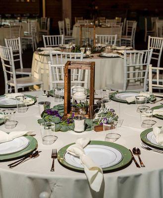 Sage green and ivory table setup with wood lanterns.