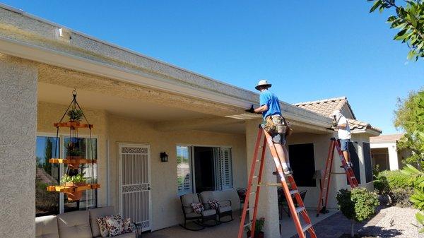 Installing the back patio gutters.