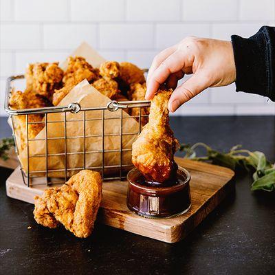 "Perfectly crispy drumstick being dipped into rich, smoky BBQ sauce bringing the ultimate flavor experience to your plate!"