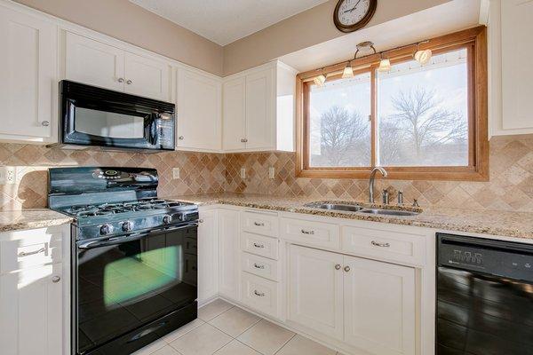 An off-white look combined with sleek hardware and added upgrades adds a timeless yet modern look to this kitchen.