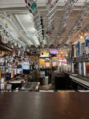 Loads of mugs hanging from the ceiling, each decorated by their owners.