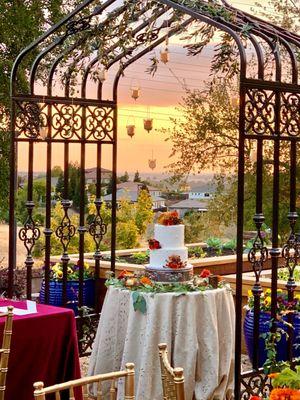 Wedding cake under arbor.