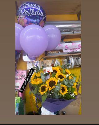 Fresh sunflowers with purple balloons