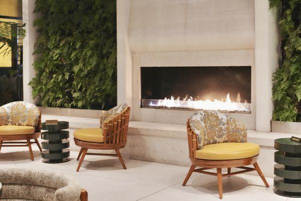 Outdoor space with a fireplace and lounge chairs.