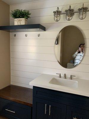 Shiplap on the wall, quartz countertop, bench with large drawer for beach towels.