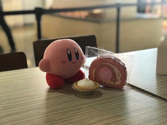 Kirby next to a strawberry Roll Cakes and tart!