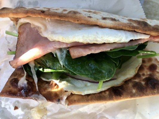 Breakfast Flatbread Sandwich with ham, egg white, Swiss Cheese, bell peppers, onion, spinach. Requested flat bread extra toasted. Yum!