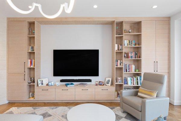 Blonde custom cabinetry for media in this San Francisco home accommodates games, DVDs, and books in a mix of open and closed storage.