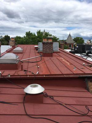 Restoring an old metal roof by cleaning , scraping and repairing