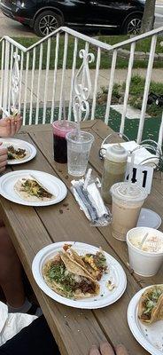 Slightly eaten steak tacos, hibiscus tea, horchata, and Mexican corn.   Steak Beef Taco Mexican Corn Fresh Water