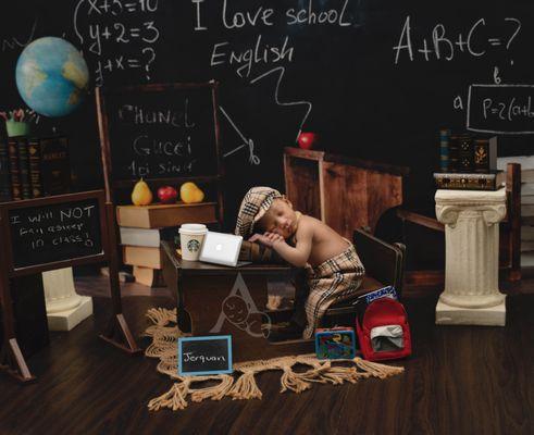 Newborn Baby boy posing on a school desk