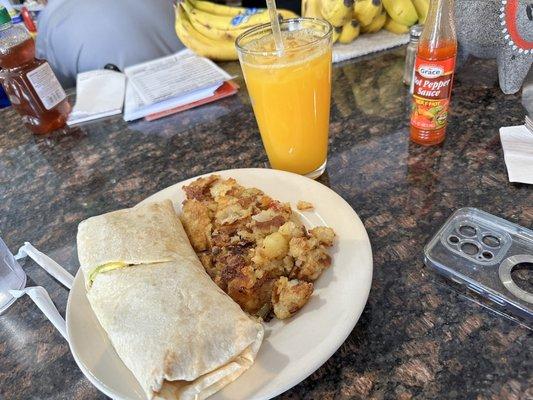 Avocado egg and Turkey Bacon breakfast wrap. House fries. Fresh orange juice