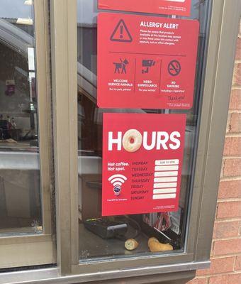 The cashier was eating and left portions of his donut laying on the open area of the drive-thru windowsill.