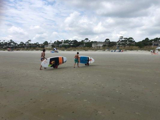 Rolling paddle boards up the beach