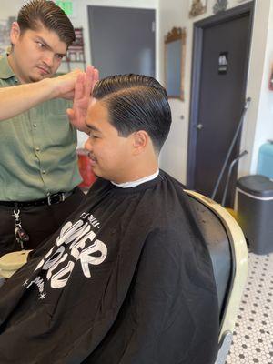 Javier, executing a contour side part haircut.