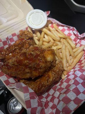 Chicken tenders dipped with sweet spicy sauce and fries