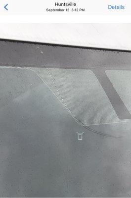 Rock directly from storage trailer caused: Small dent on hood and J-shape crack on windshield