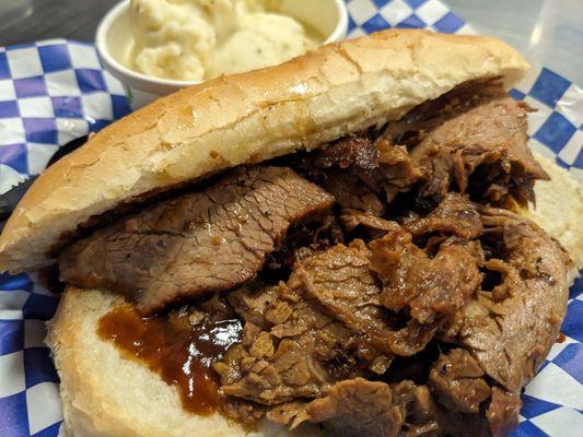 Tri-tip sandwich with BBQ sauce and mashed potatoes with gravy.