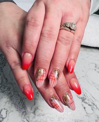 Ombré nails with orange and a gold/orange geometric design.