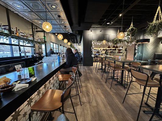 A view down the bar. The kitchen and main seating is on the right. There is also more seating beyond the bar.