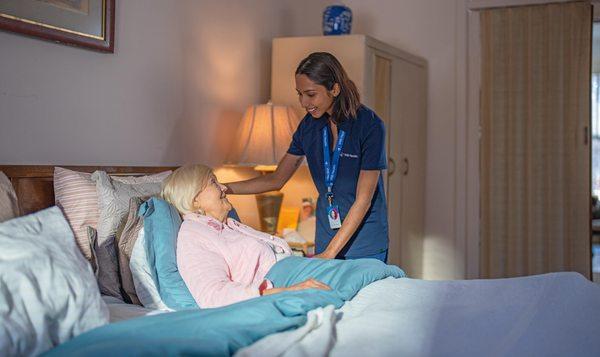 One of our team members consoling a patient in bed.