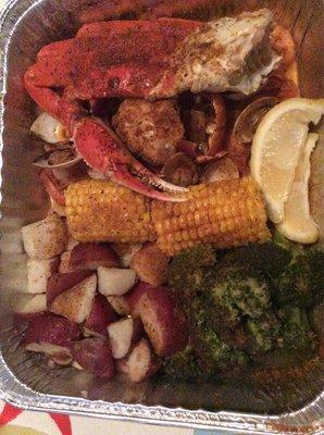 Lobster tail, shrimps, clams, and crab in Cajun sauce (corn, broccoli, and potatoes are the sides)