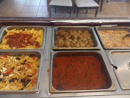 Hot foods including sausage and peppers and onions and meatballs and pasta