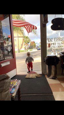 my grandson with the broom in the barbershop