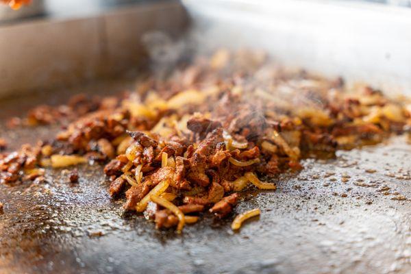 Delicious Al pastor mixed with onion ready on the grill