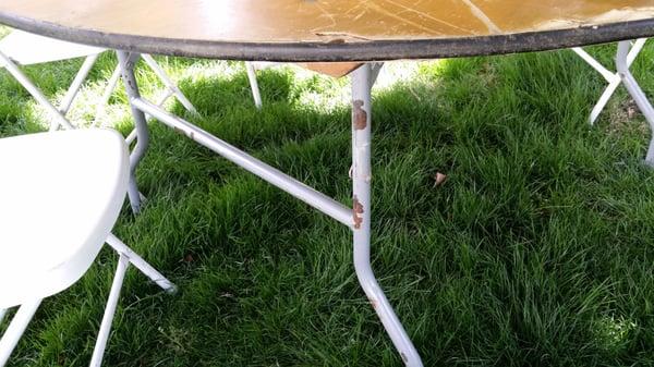 Chipped paint, rusty legs, scratched up, chunks of the top missing, uneven...one hell of a table